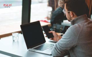 Professional smiling while working on confidential files in a shared space, confident in screen privacy and data security.